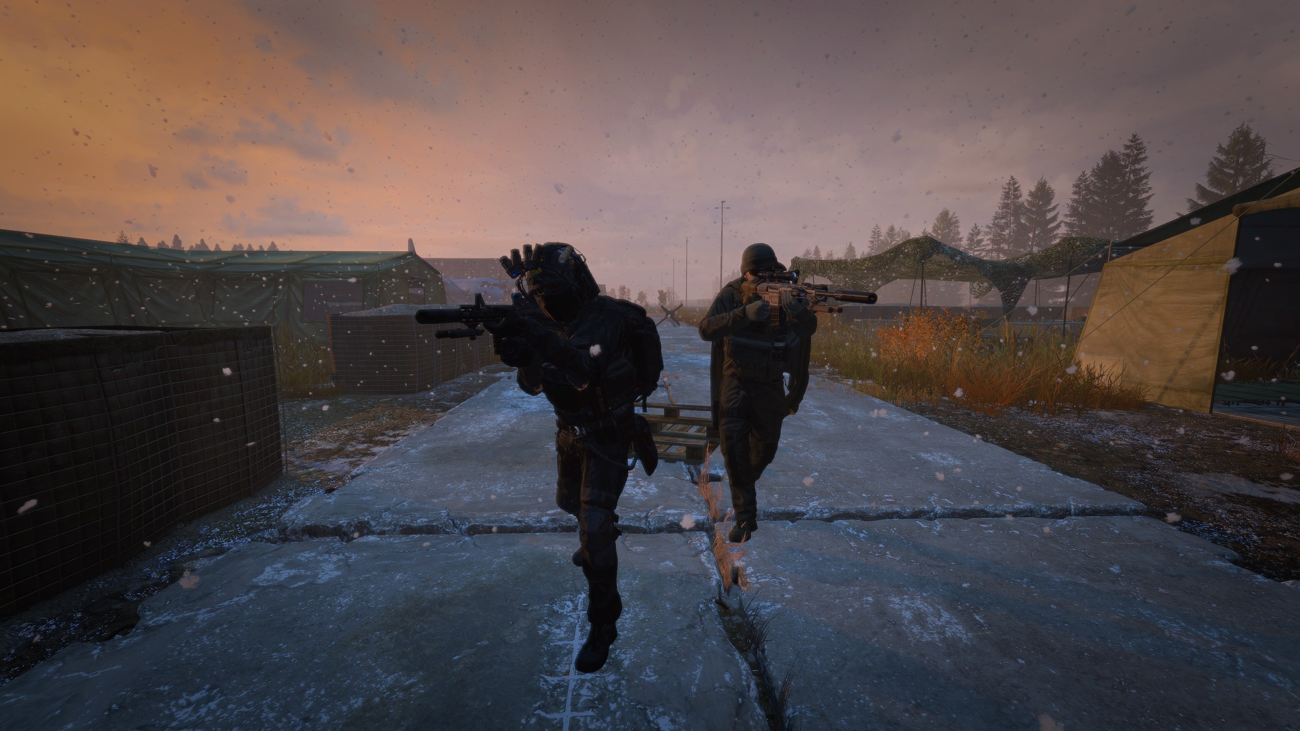 Two armed survivors in tactical gear walking through a snowy post-apocalyptic landscape at sunset in DayZ, showcasing the intense survival atmosphere of Bandits Hideout server